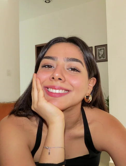 Hannah Zazueta sonriendo, con la mano en la mejilla
